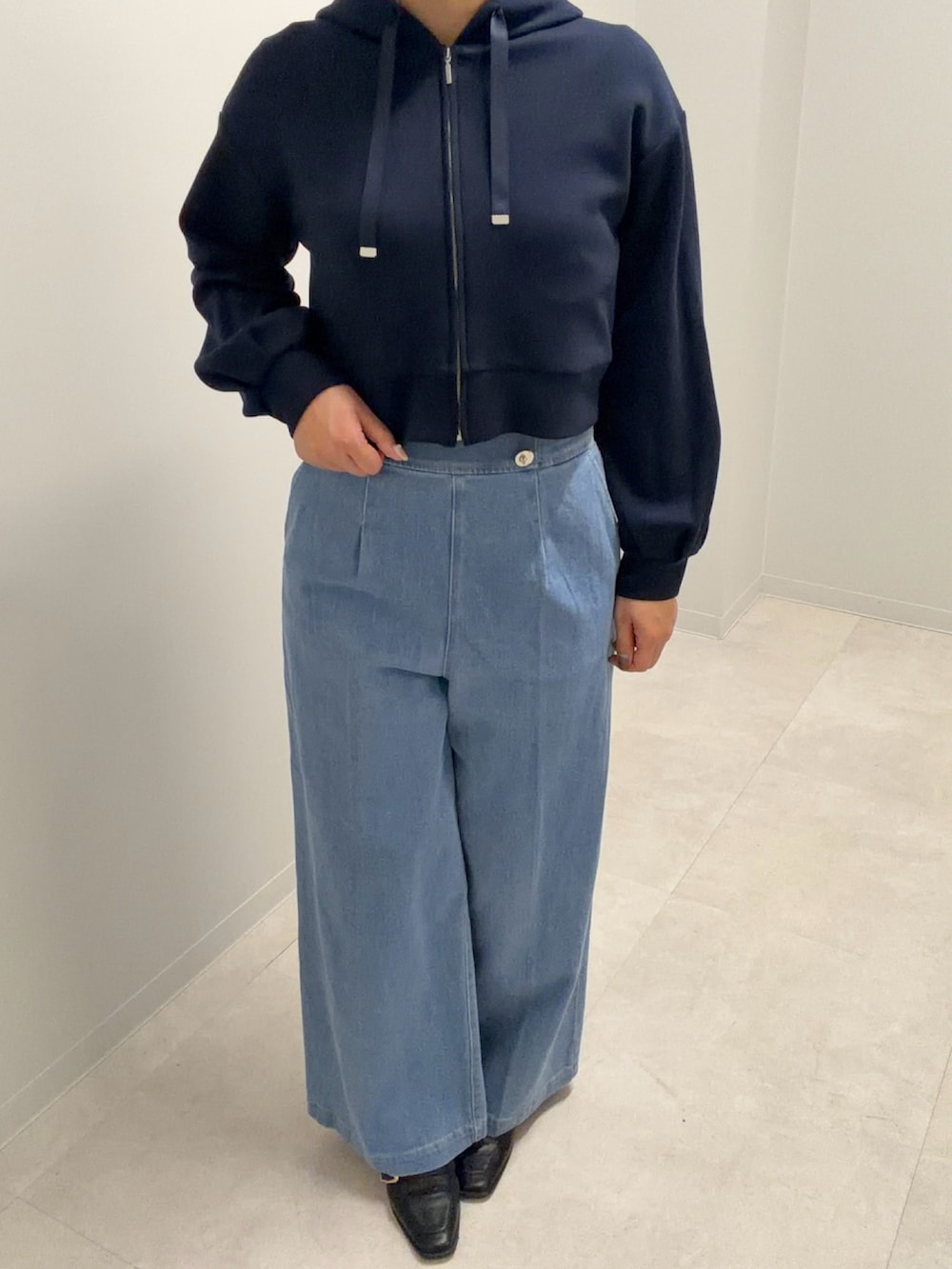 ブルー系のパーカー、ブルー系のデニムパンツを着用したレディースの春コーディネートの2枚目の写真