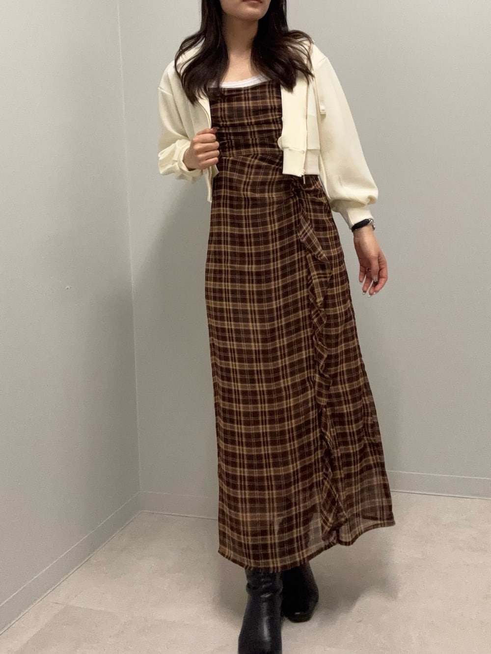 イエロー系のパーカー、ブラウン系のワンピースを着用したレディースの春コーディネートの2枚目の写真