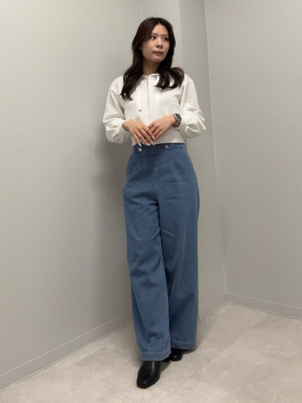 ブルー系のデニムパンツ、ホワイト系のパーカーを着用したレディースの春コーディネートの2枚目の写真