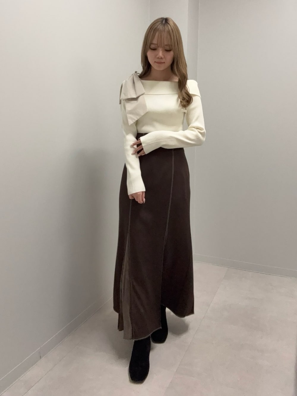 ホワイト系のニット/セーター、ブラウン系のスカートを着用したレディースの冬コーディネートの4枚目の写真