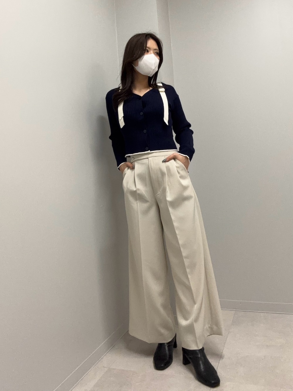 ブルー系のニット/セーター、ホワイト系のその他パンツを着用したレディースの春コーディネートの2枚目の写真