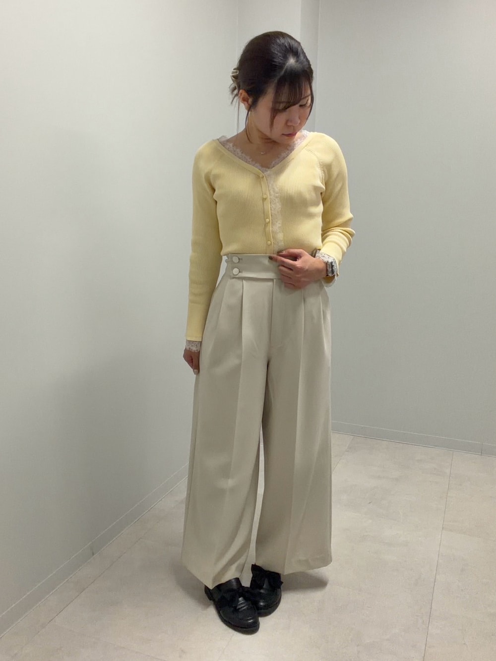 イエロー系のニット/セーター、ベージュ系のその他パンツを着用したレディースの春コーディネートの2枚目の写真