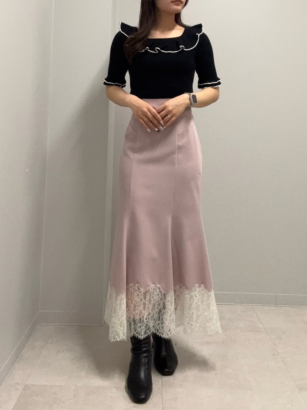 ブラック系のニット/セーター、ピンク系のスカートを着用したレディースの春コーディネートの3枚目の写真