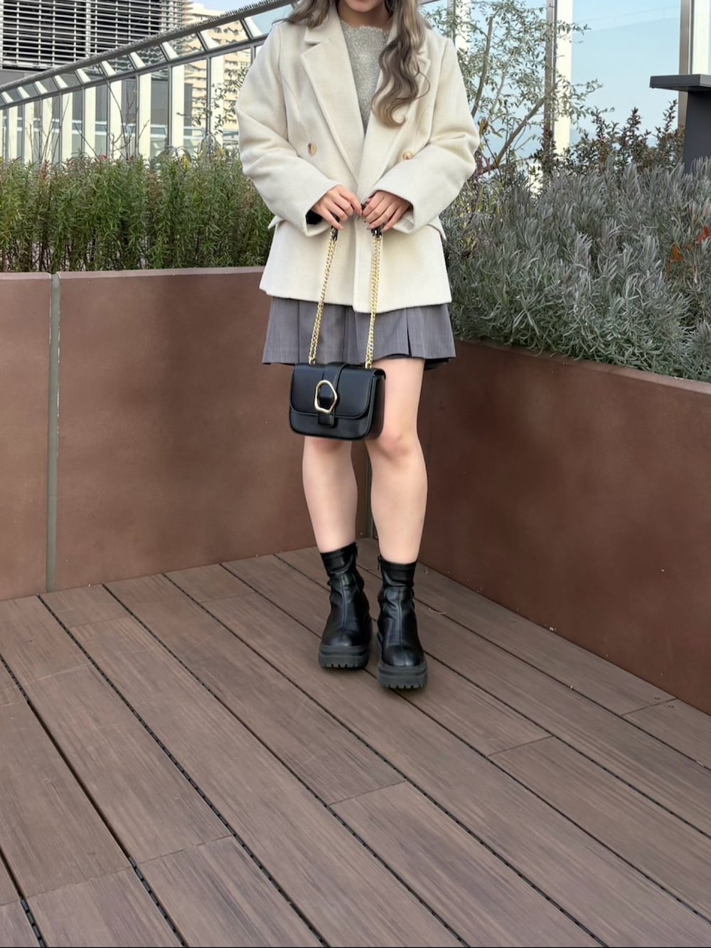 グレー系のその他パンツ、ベージュ系のニット/セーター、ベージュ系のチェスターコートを着用したレディースの冬コーディネートの2枚目の写真