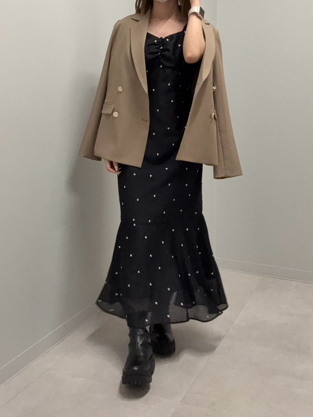 ブラウン系のテーラードジャケット、ブラック系のワンピース、ブラック系のブーツを着用したレディースの春コーディネートの3枚目の写真