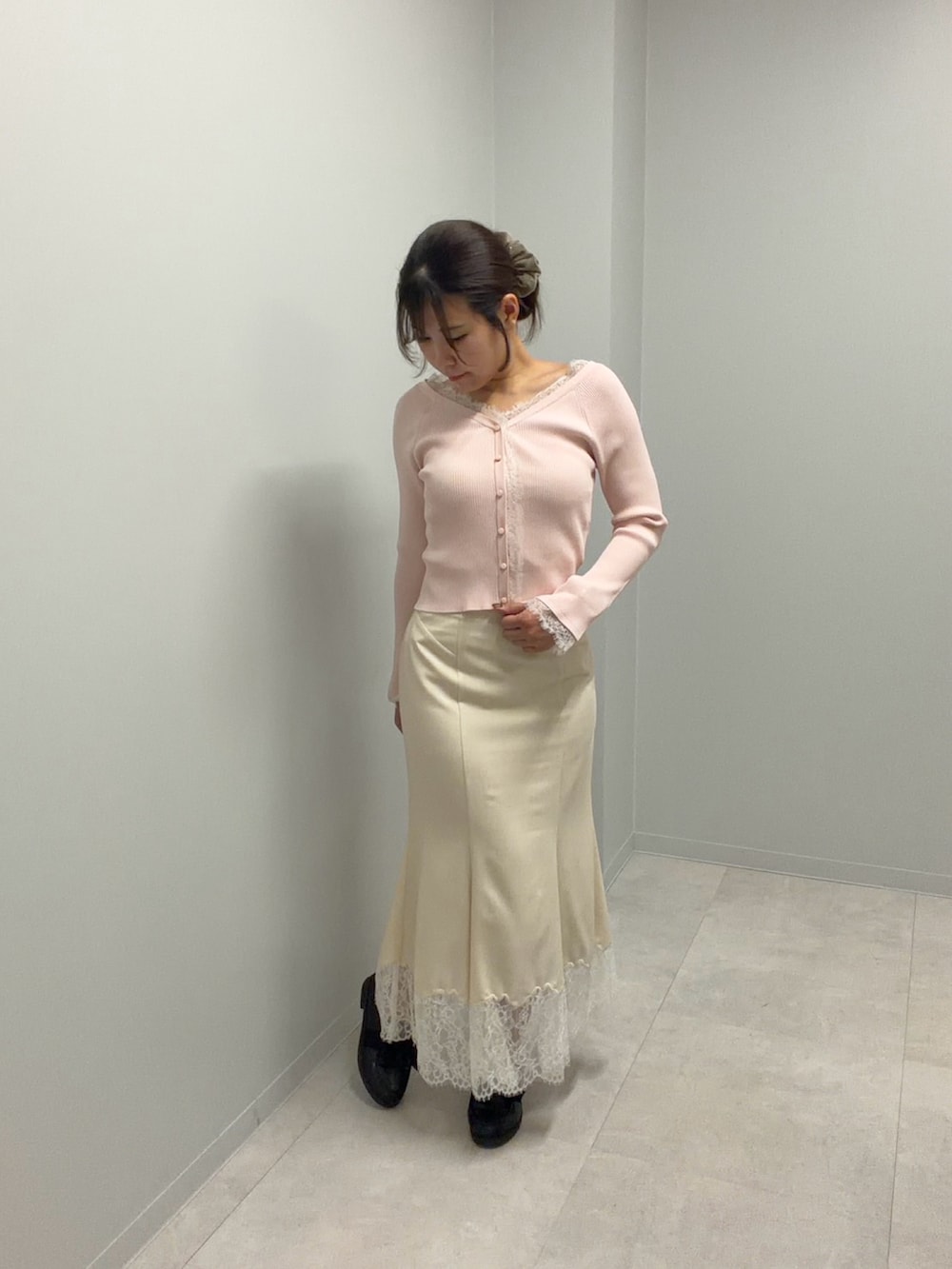 ピンク系のニット/セーター、ホワイト系のスカートを着用したレディースの春コーディネートの2枚目の写真