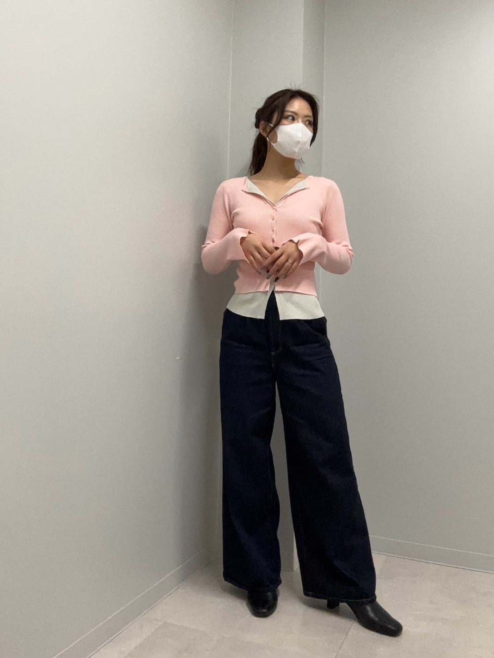 ピンク系のニット/セーター、ブルー系のデニムパンツを着用したレディースの春コーディネートの2枚目の写真