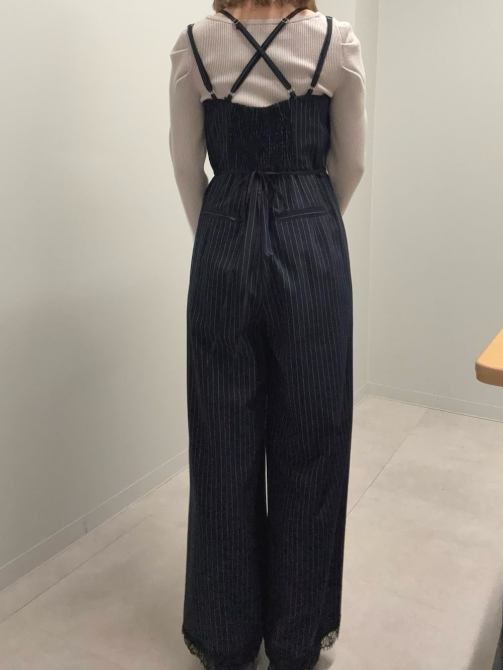 ブルー系のつなぎ/オールインワン、ピンク系のニット/セーター、ブラック系のブーツを着用したレディースの春コーディネートの3枚目の写真