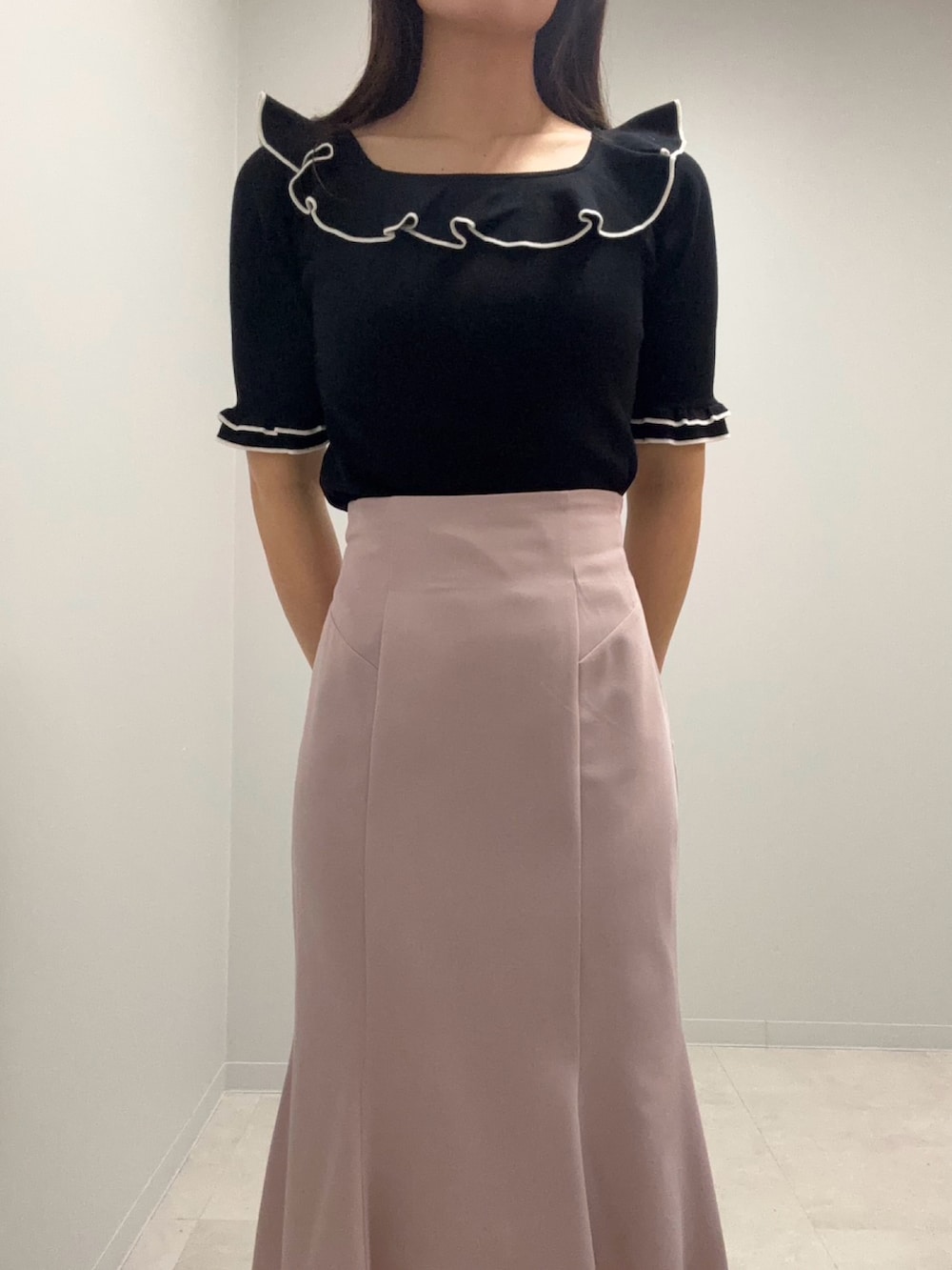 ブラック系のニット/セーター、ピンク系のスカートを着用したレディースの春コーディネートの4枚目の写真