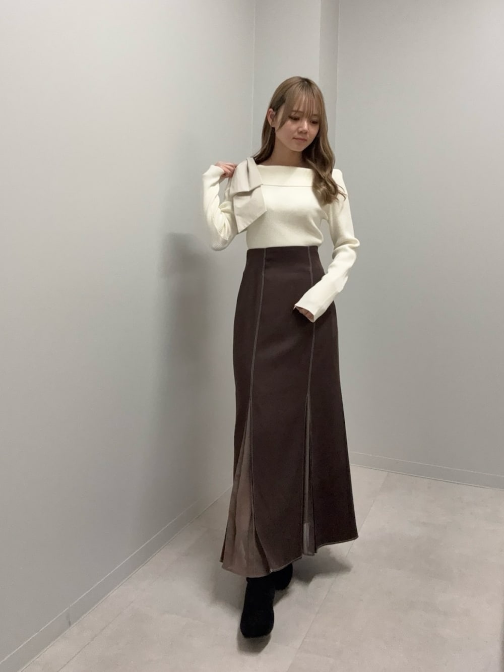 ホワイト系のニット/セーター、ブラウン系のスカートを着用したレディースの冬コーディネートの3枚目の写真