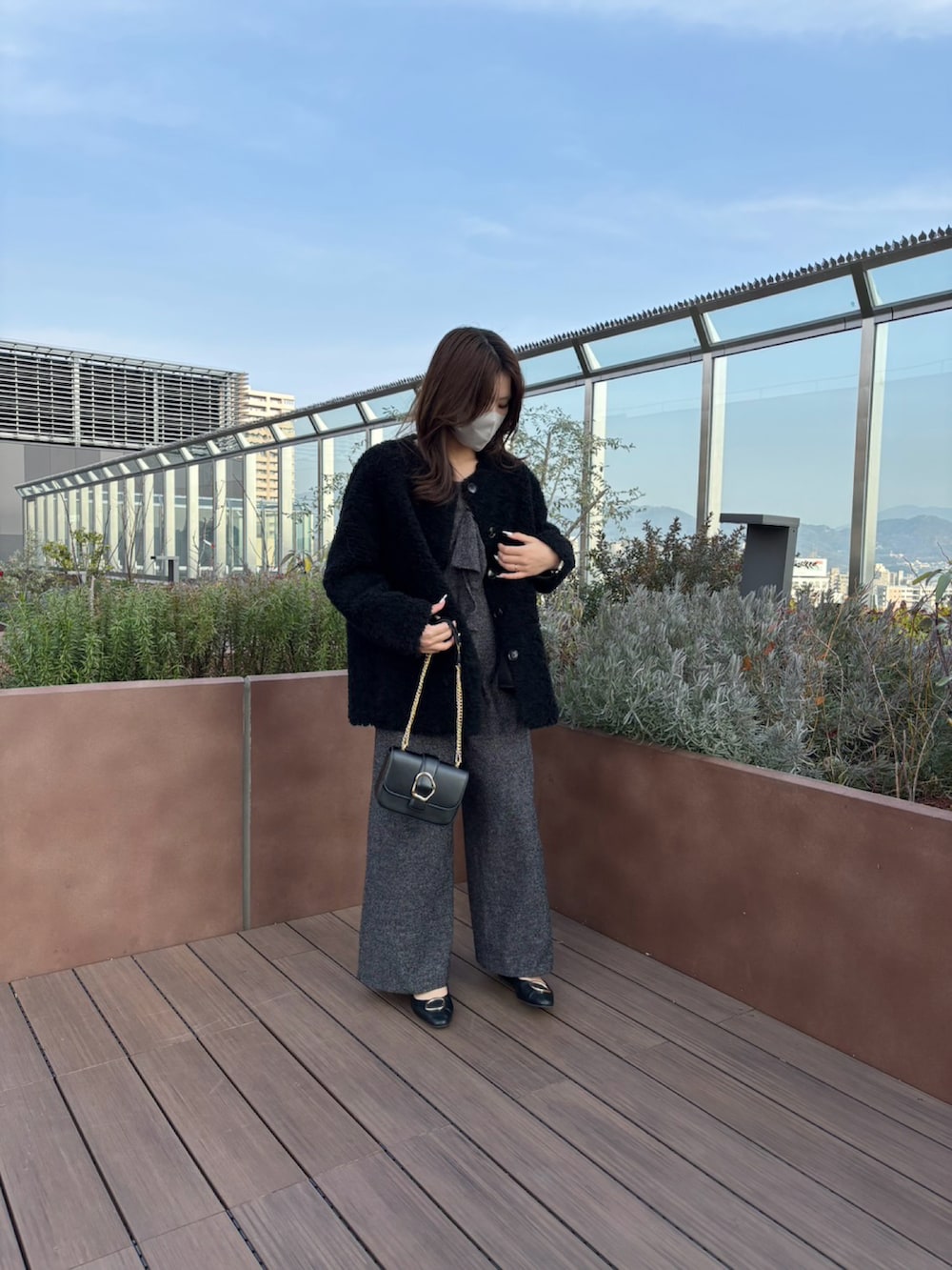 ブラック系のノーカラージャケット、ブラック系のサロペット/オーバーオール、ブラック系のショルダーバッグを着用したレディースの冬コーディネートの2枚目の写真