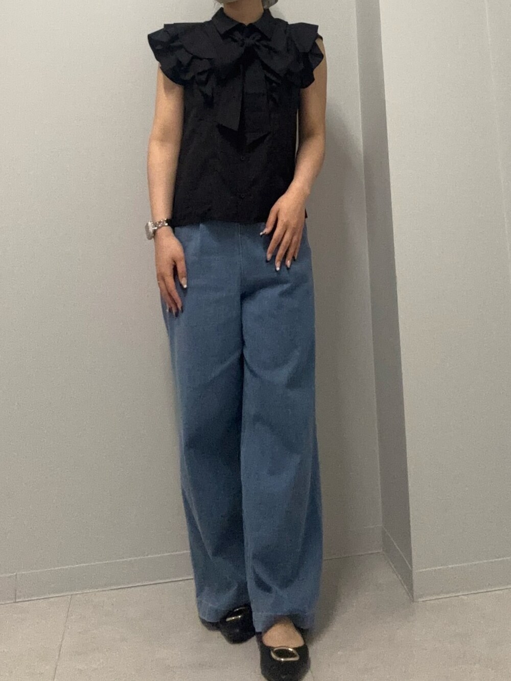 ブルー系のデニムパンツ、ブラック系のシャツ/ブラウスを着用したレディースの春コーディネートの2枚目の写真