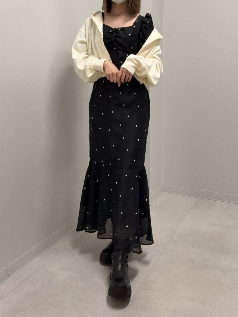 イエロー系のパーカー、ブラック系のワンピース、ブラック系のブーツを着用したレディースの春コーディネートの2枚目の写真