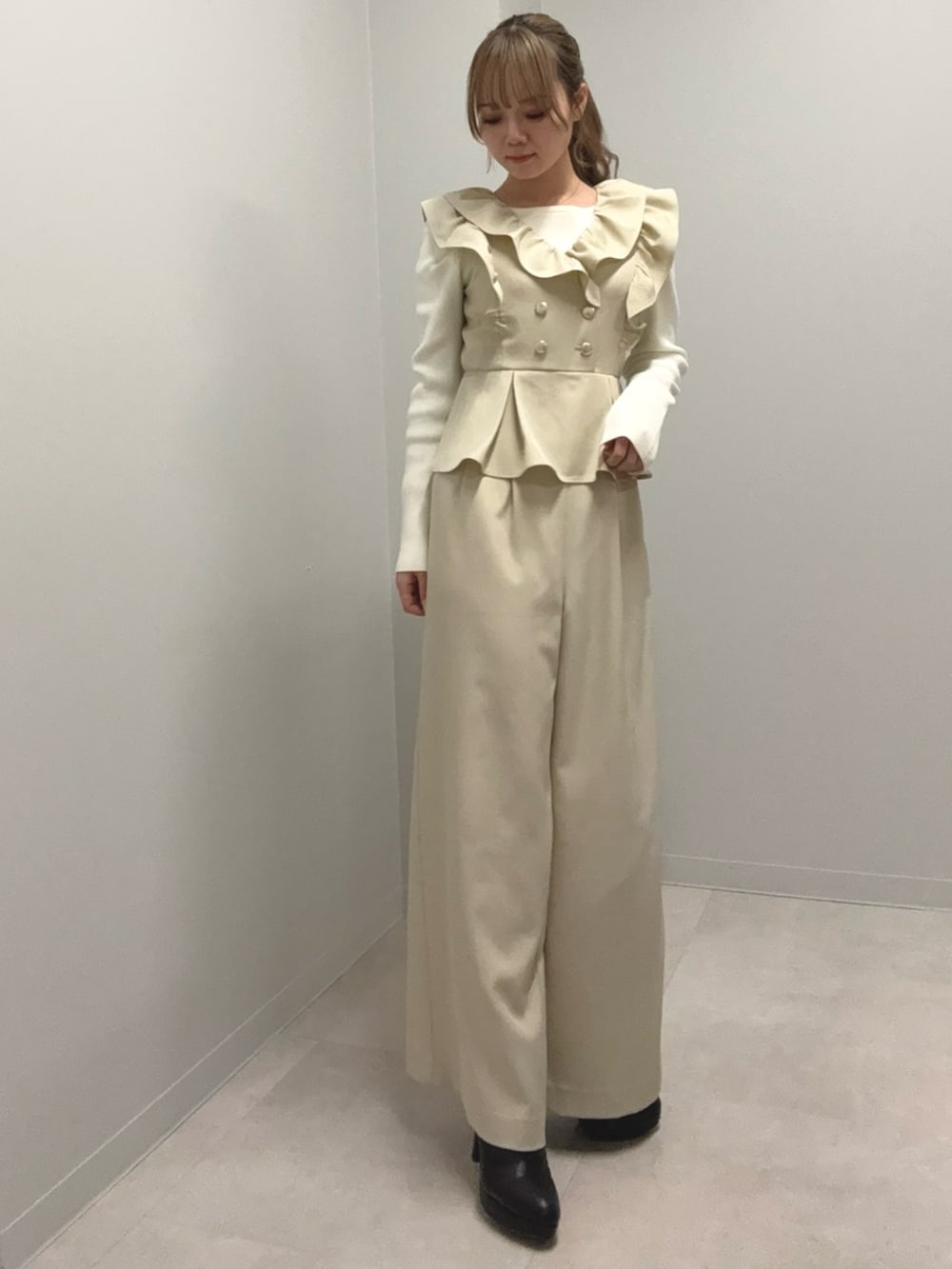 ホワイト系のニット/セーター、ベージュ系のつなぎ/オールインワン、ブラック系のブーツを着用したレディースの冬コーディネートの3枚目の写真