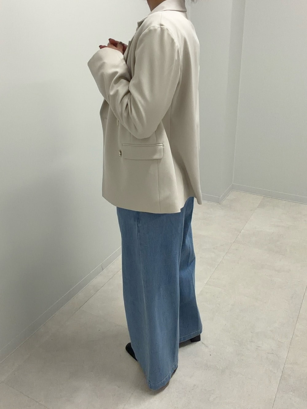 ベージュ系のテーラードジャケット、ピンク系のニット/セーター、ブルー系のデニムパンツを着用したレディースの春コーディネートの2枚目の写真