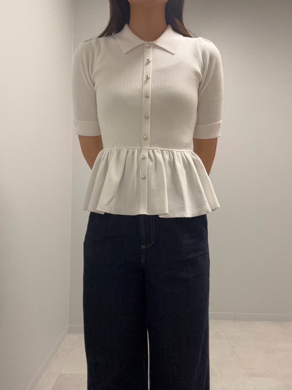 ホワイト系のニット/セーター、ブルー系のデニムパンツを着用したレディースの春コーディネートの4枚目の写真