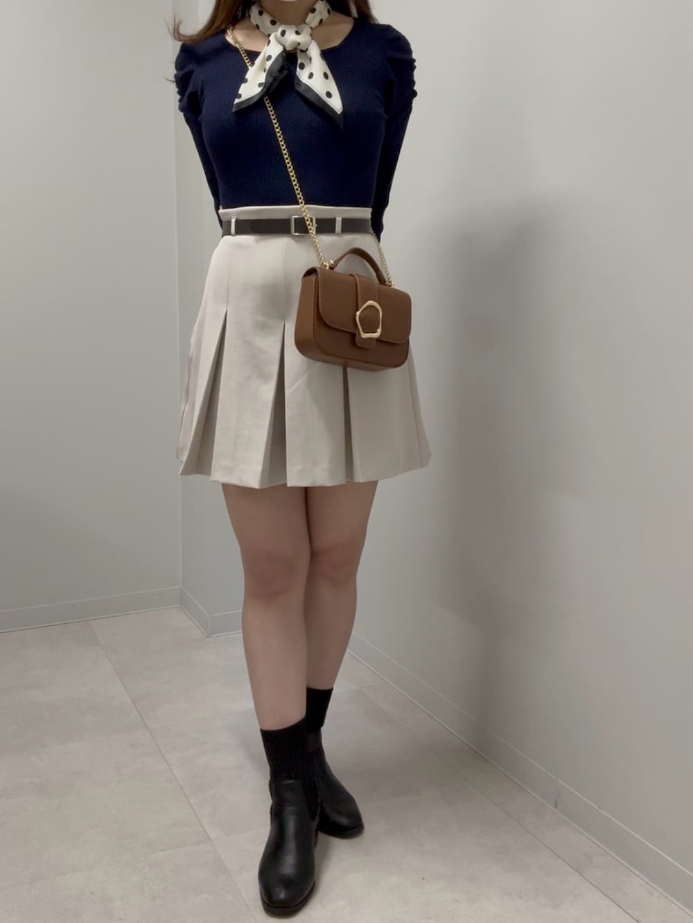 ブラウン系のショルダーバッグ、ブルー系のニット/セーター、ベージュ系のその他パンツを着用したレディースの春コーディネートの2枚目の写真