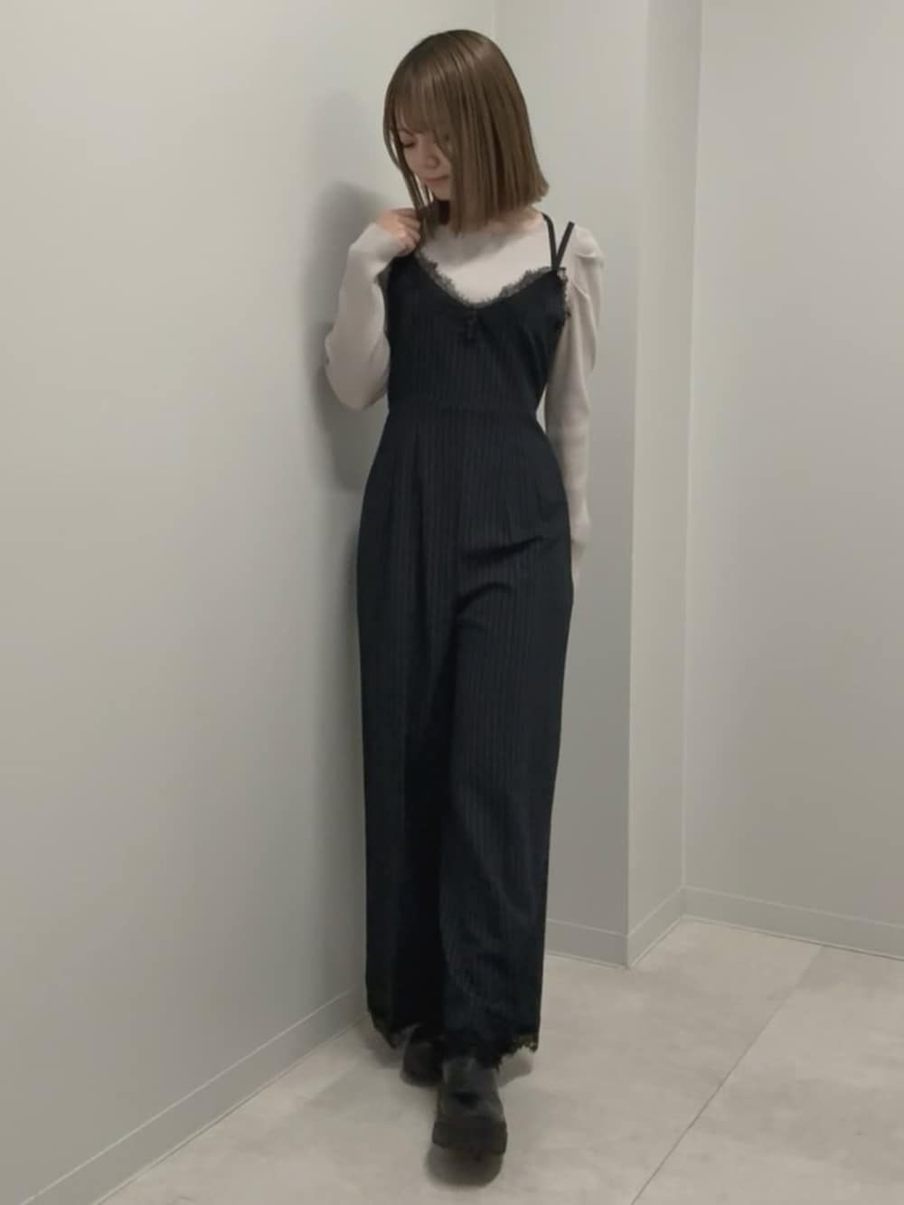 ブルー系のつなぎ/オールインワン、ピンク系のニット/セーター、ブラック系のブーツを着用したレディースの春コーディネートの2枚目の写真