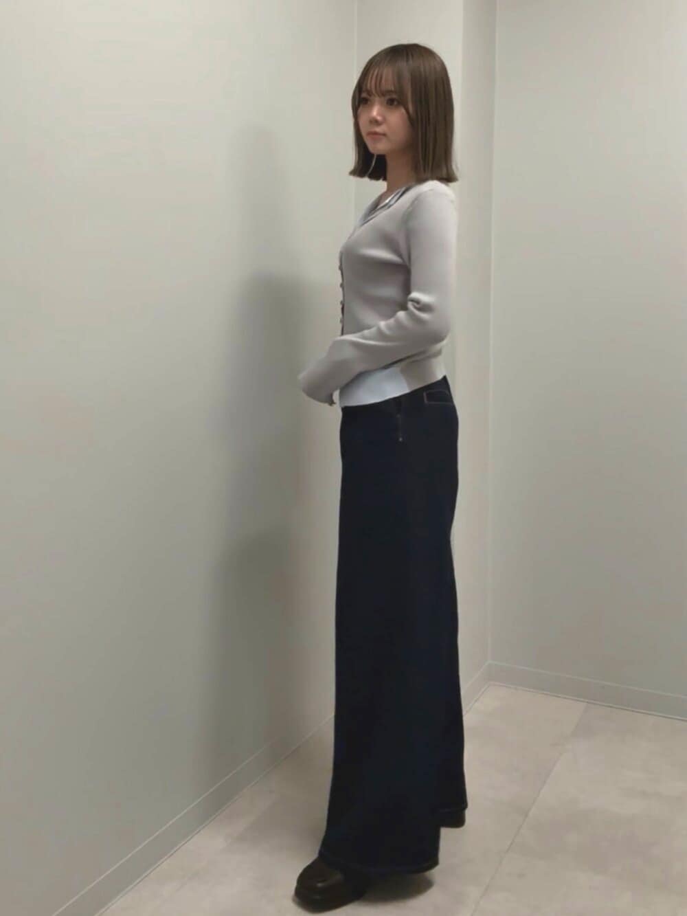 ブルー系のデニムパンツ、グレー系のニット/セーターを着用したレディースの春コーディネートの2枚目の写真