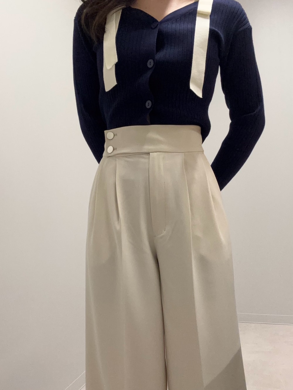 ブルー系のニット/セーター、ホワイト系のその他パンツを着用したレディースの春コーディネートの4枚目の写真