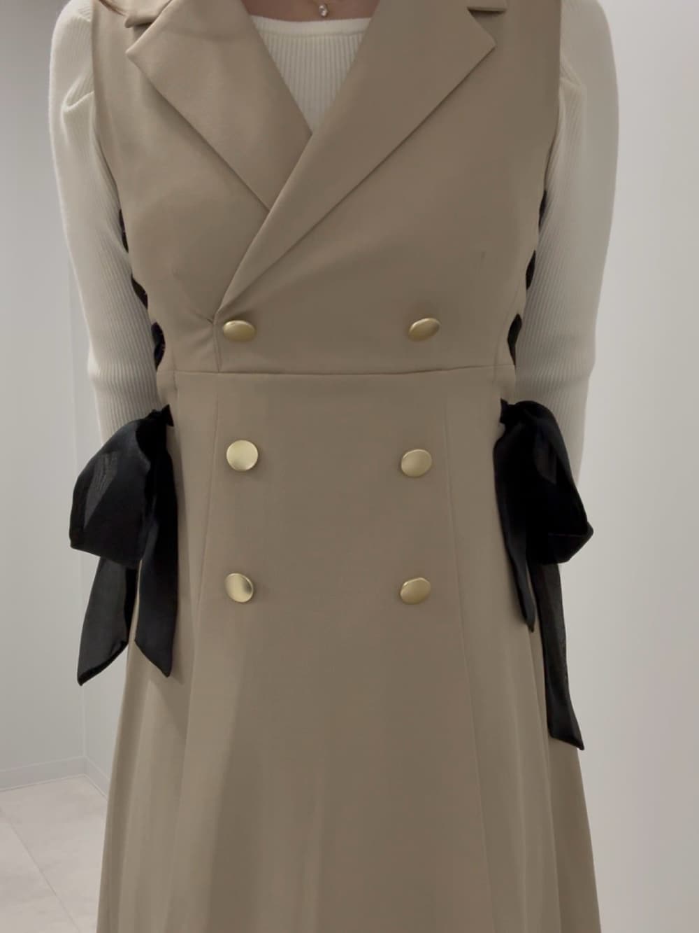 ホワイト系のニット/セーター、ベージュ系のワンピース、ベージュ系のブーツを着用したレディースの春コーディネートの3枚目の写真