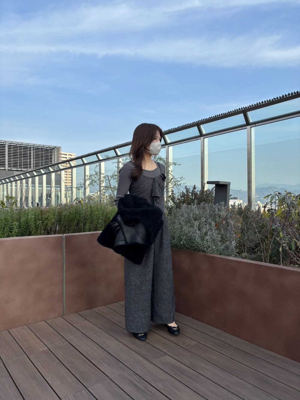 ブラック系のノーカラージャケット、ブラック系のサロペット/オーバーオール、ブラック系のショルダーバッグを着用したレディースの冬コーディネートの5枚目の写真