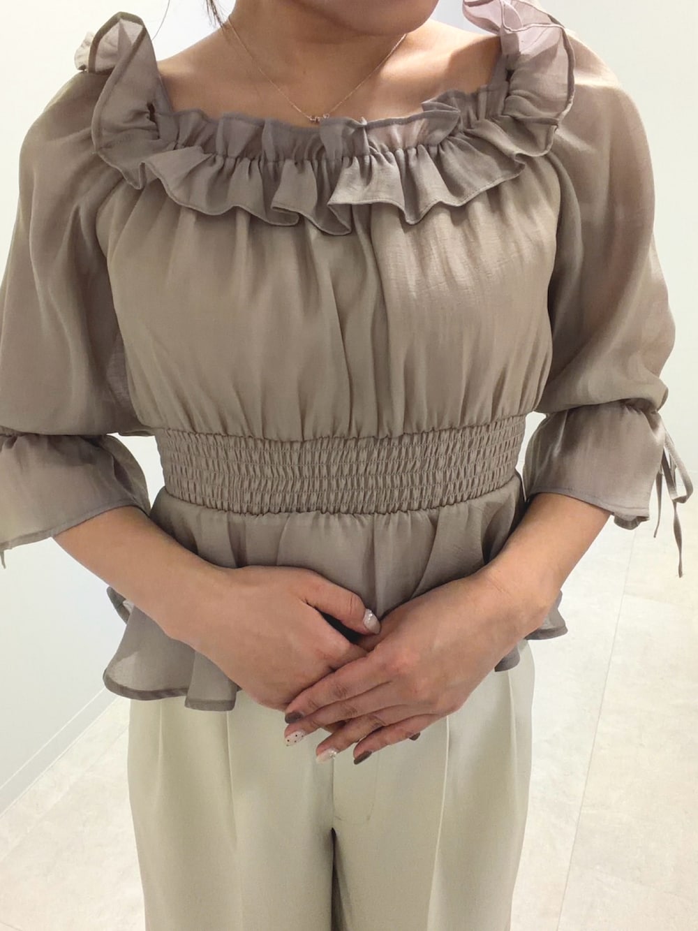 グレー系のシャツ/ブラウス、ベージュ系のその他パンツを着用したレディースの春コーディネートの2枚目の写真