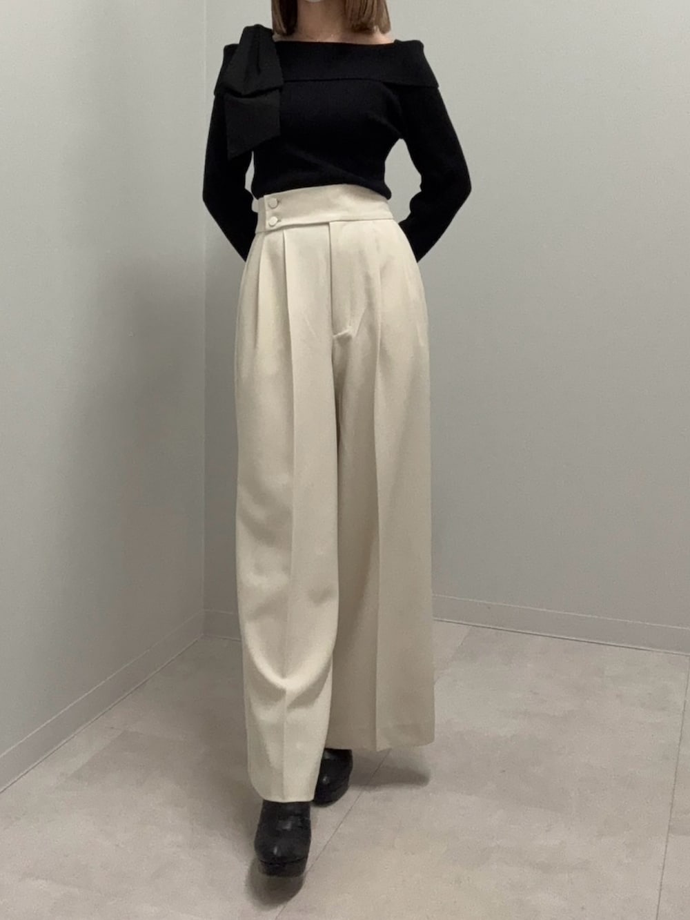 ブラック系のニット/セーター、ベージュ系のその他パンツ、ブラック系のブーツを着用したレディースの春コーディネートの3枚目の写真