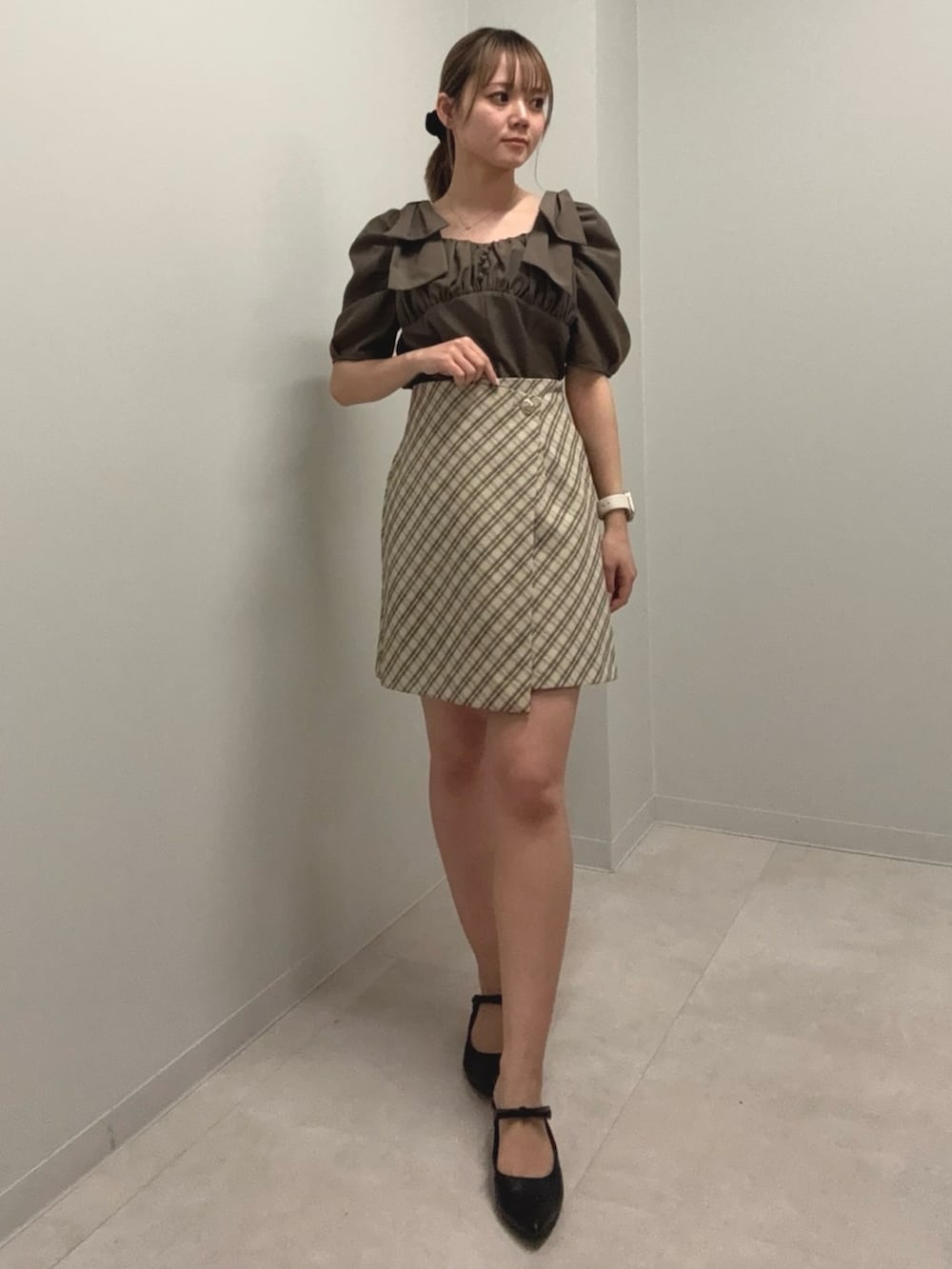 ブラウン系のシャツ/ブラウス、ベージュ系のスカート、ブラック系のパンプスを着用したレディースの春コーディネートの2枚目の写真