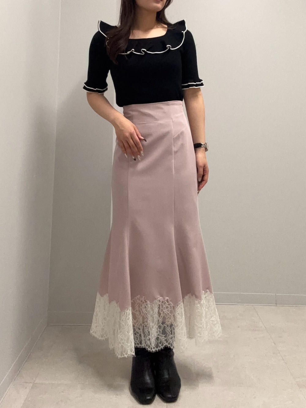 ブラック系のニット/セーター、ピンク系のスカートを着用したレディースの春コーディネートの2枚目の写真