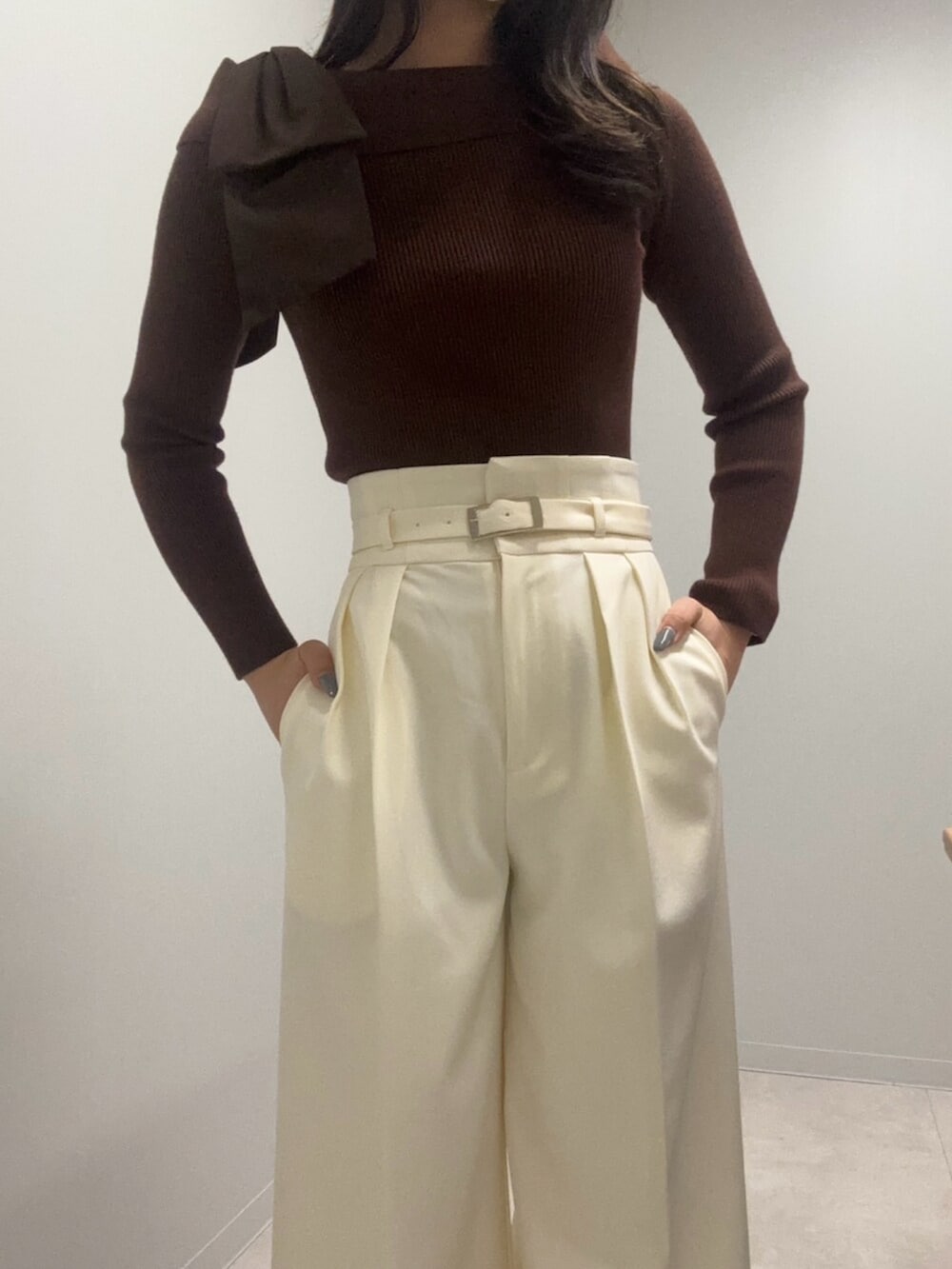 ブラウン系のニット/セーター、ホワイト系のその他パンツ、ベージュ系のショルダーバッグを着用したレディースの春コーディネートの5枚目の写真