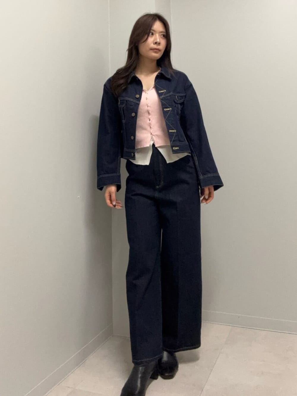 ブルー系のデニムパンツ、ピンク系のニット/セーター、ブルー系のデニムジャケットを着用したレディースの春コーディネートの3枚目の写真