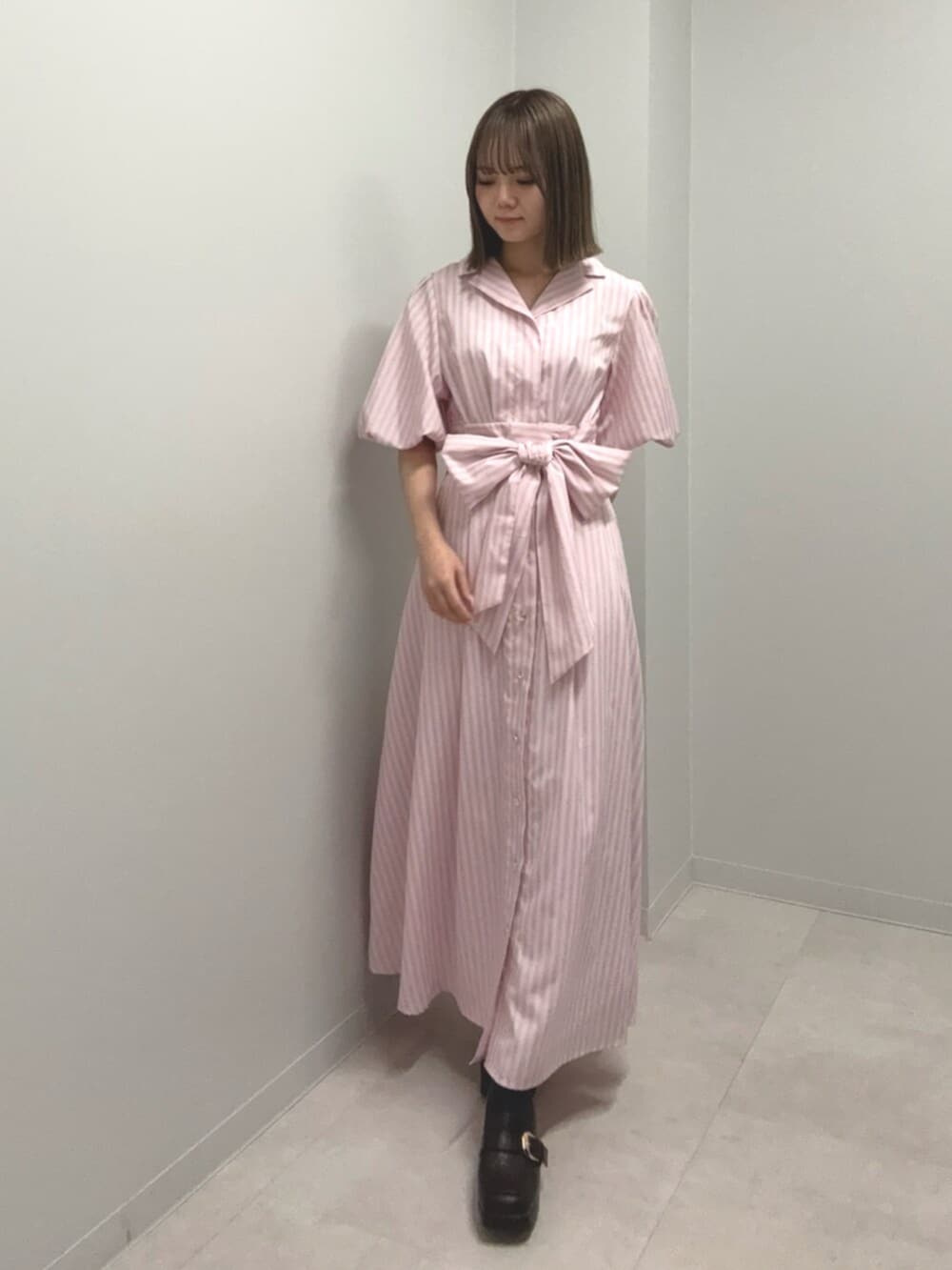 ピンク系のワンピースを着用したレディースの春コーディネートの2枚目の写真