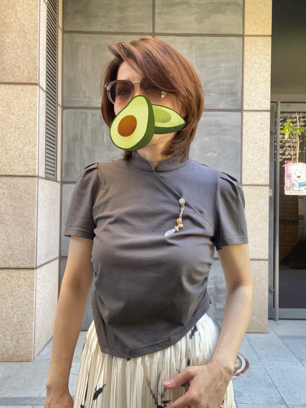 ホワイト系のスニーカー、グリーン系のTシャツ/カットソー、ベージュ系のスカートを着用したレディースの夏コーディネートの2枚目の写真