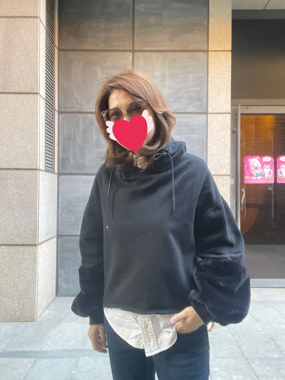 ブルー系のデニムパンツ、ブラック系のスニーカー、ブラック系のパーカーを着用したレディースの冬コーディネートの3枚目の写真