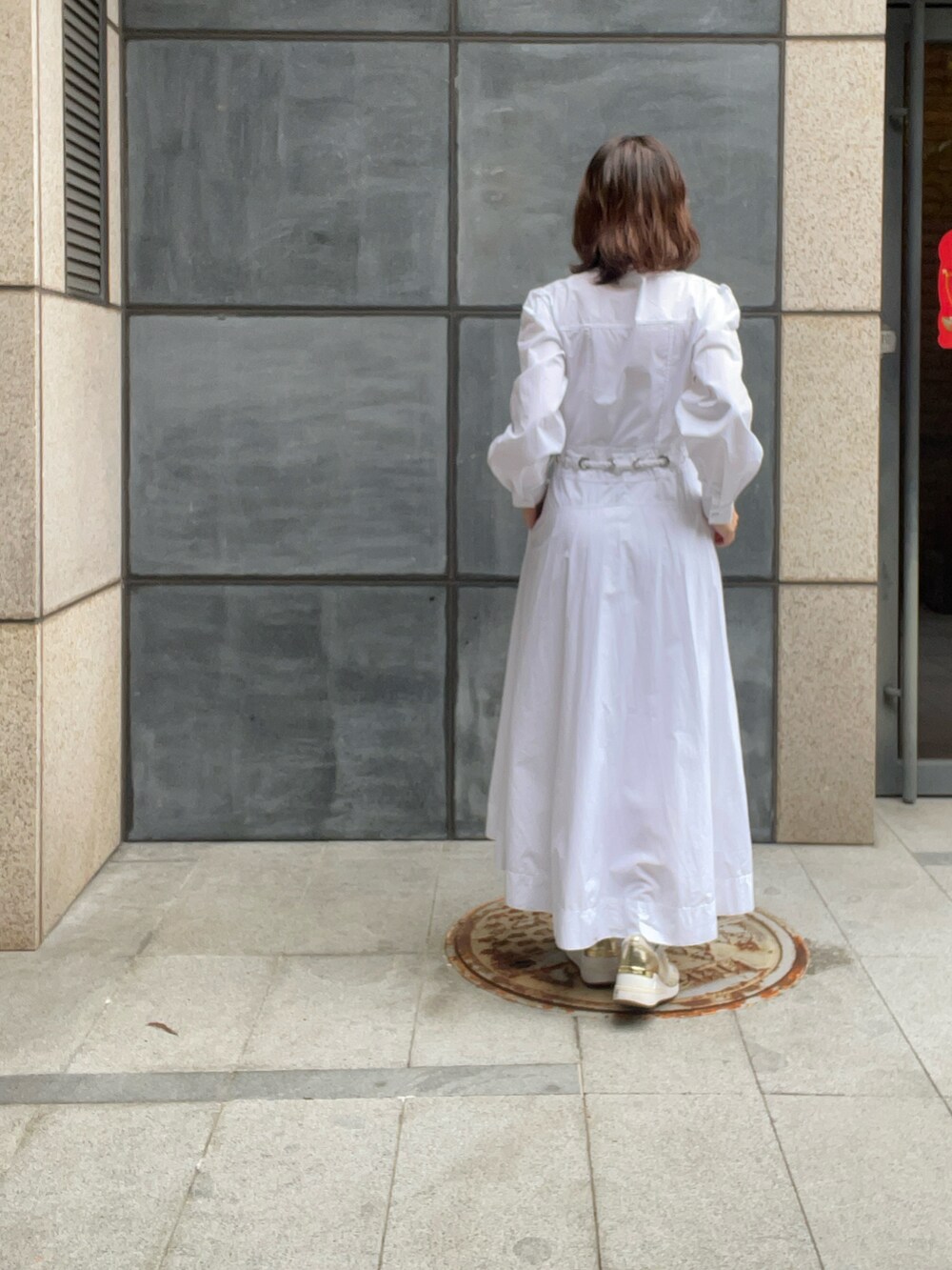 ベージュ系のスニーカー、ホワイト系のシャツワンピース、ブラウン系のサングラスを着用したレディースの春コーディネートの4枚目の写真