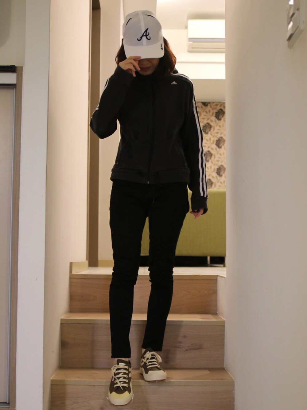 ブラック系のスタジャン、ブラック系のチノパンツ、グリーン系のスニーカーを着用したレディースの春コーディネートの2枚目の写真