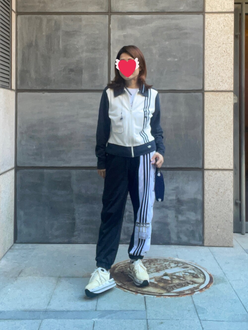 ブラック系のチノパンツ、ホワイト系のTシャツ/カットソー、ベージュ系のスニーカーを着用したレディースの冬コーディネートの2枚目の写真