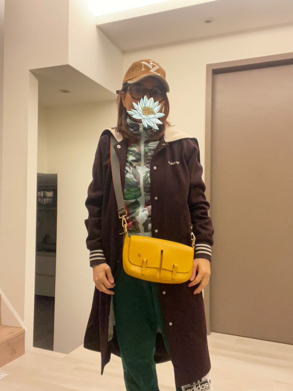 ブラウン系のモッズコート、グリーン系のチノパンツ、その他のスタジャンを着用したレディースの春コーディネートの4枚目の写真