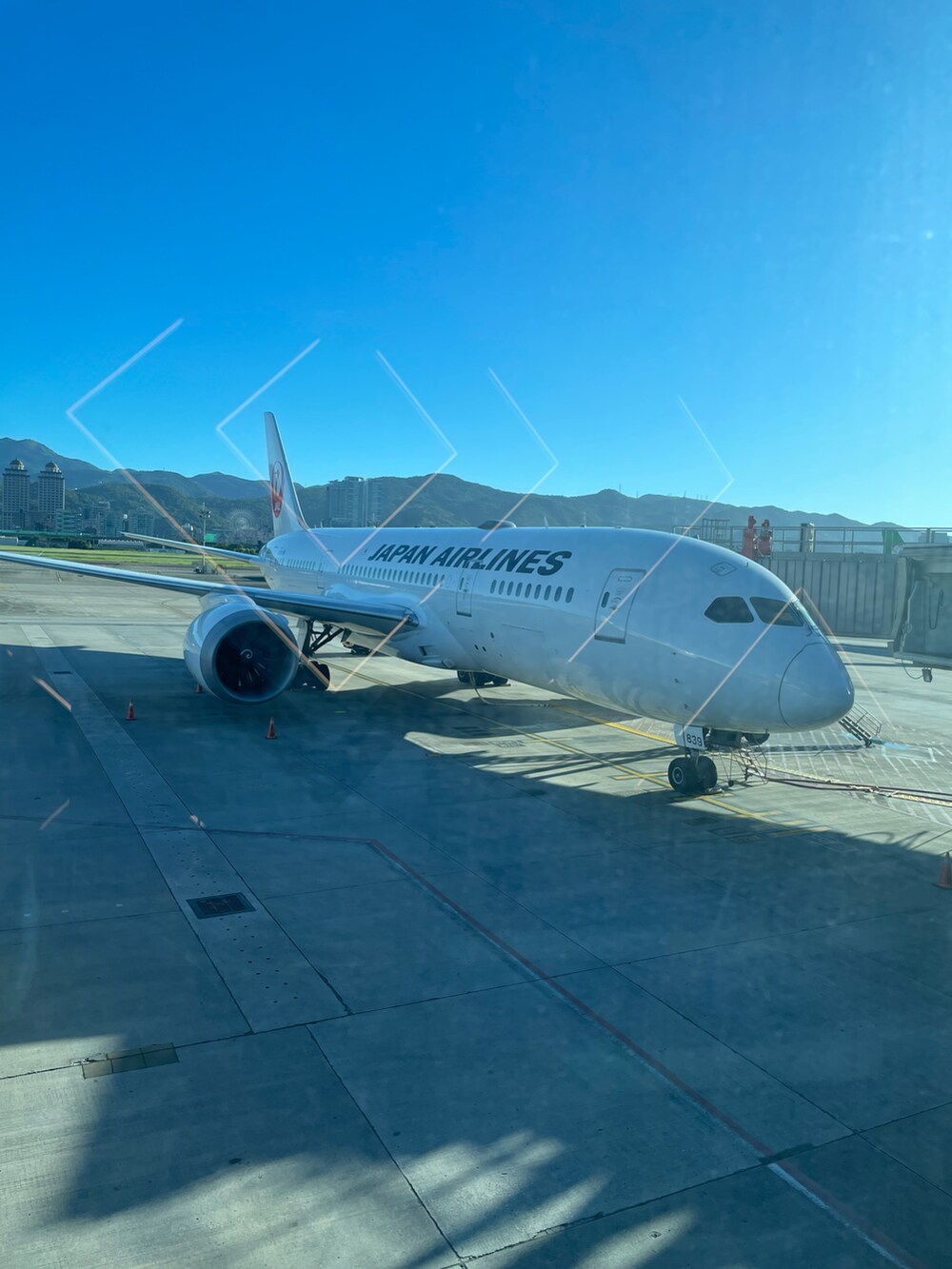 グレー系のスタジャン、イエロー系のジャンパースカート、ブラック系のスニーカーを着用したレディースの夏コーディネートの4枚目の写真