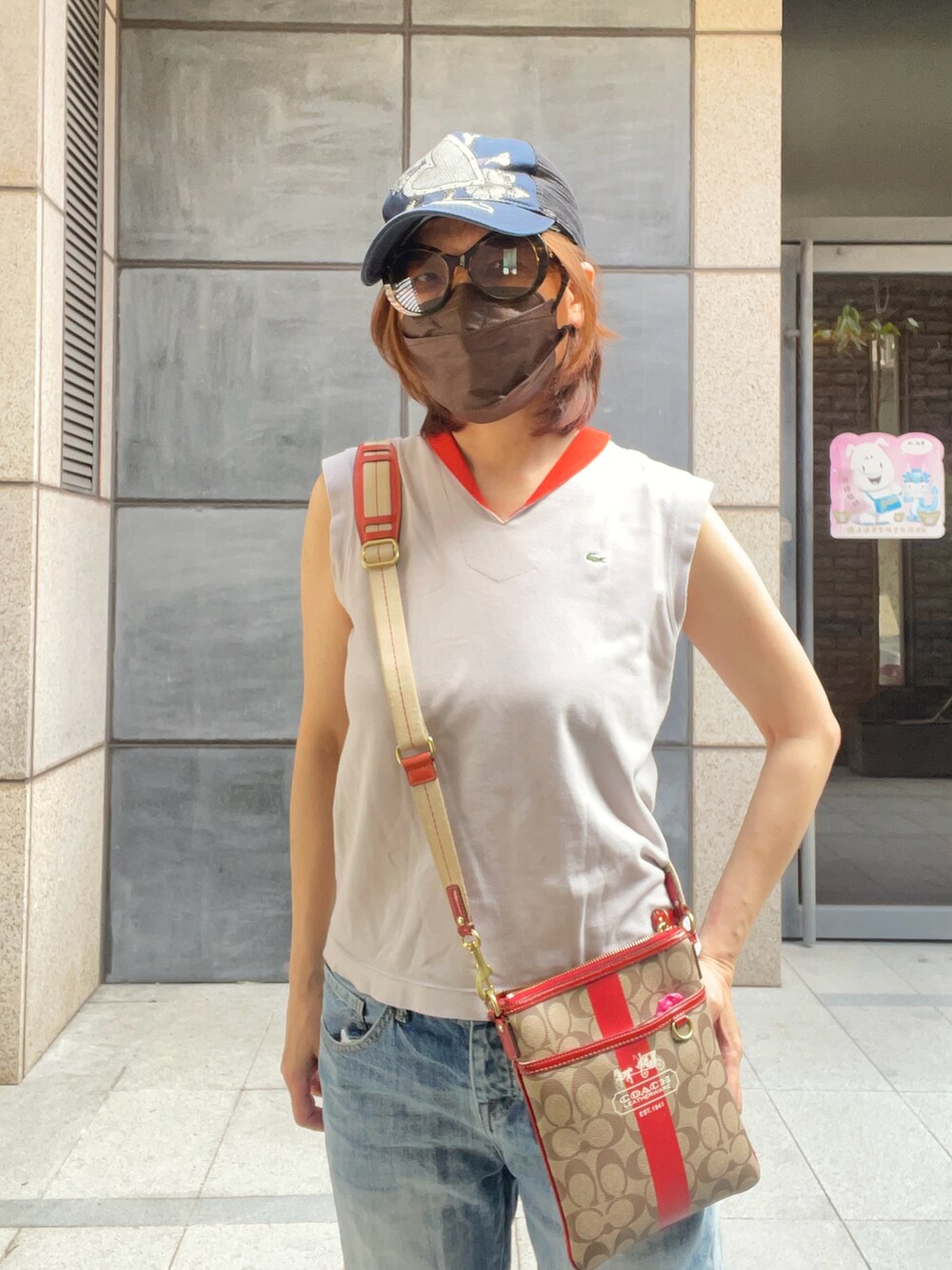 シルバー系のポロシャツ、ブルー系のビーチサンダル、ブルー系のデニムパンツを着用したレディースの秋コーディネートの2枚目の写真