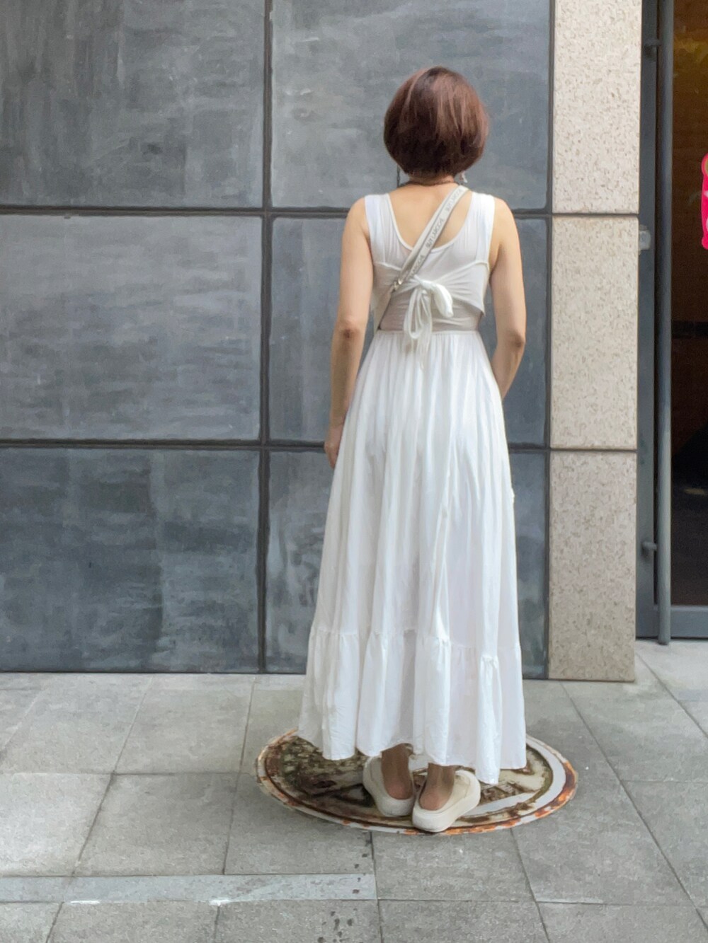 ホワイト系のワンピース、ベージュ系のスリッポン、その他の財布を着用したレディースの夏コーディネートの3枚目の写真