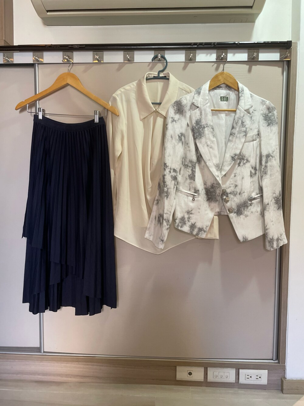 ベージュ系のビジネスシャツ、ホワイト系のテーラードジャケット、ブルー系のスカートを着用したレディースの秋コーディネートの5枚目の写真