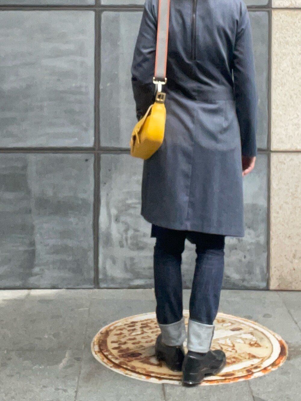 グレー系のワンピース、イエロー系のショルダーバッグ、ブラック系のローファーを着用したレディースの春コーディネートの3枚目の写真