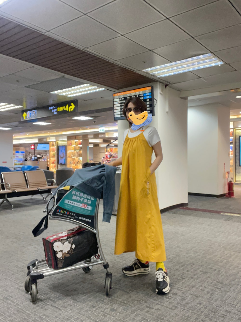 グレー系のスタジャン、イエロー系のジャンパースカート、ブラック系のスニーカーを着用したレディースの夏コーディネートの3枚目の写真