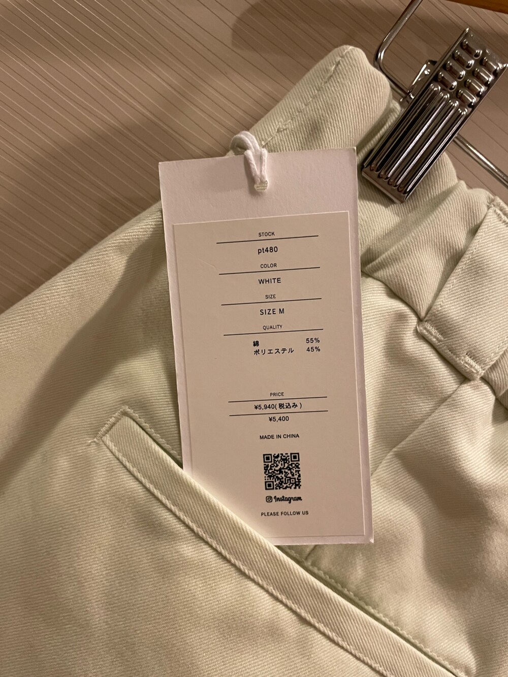 ピンク系のマウンテンパーカー、その他のスタジャン、ベージュ系のチノパンツを着用したレディースの冬コーディネートの3枚目の写真