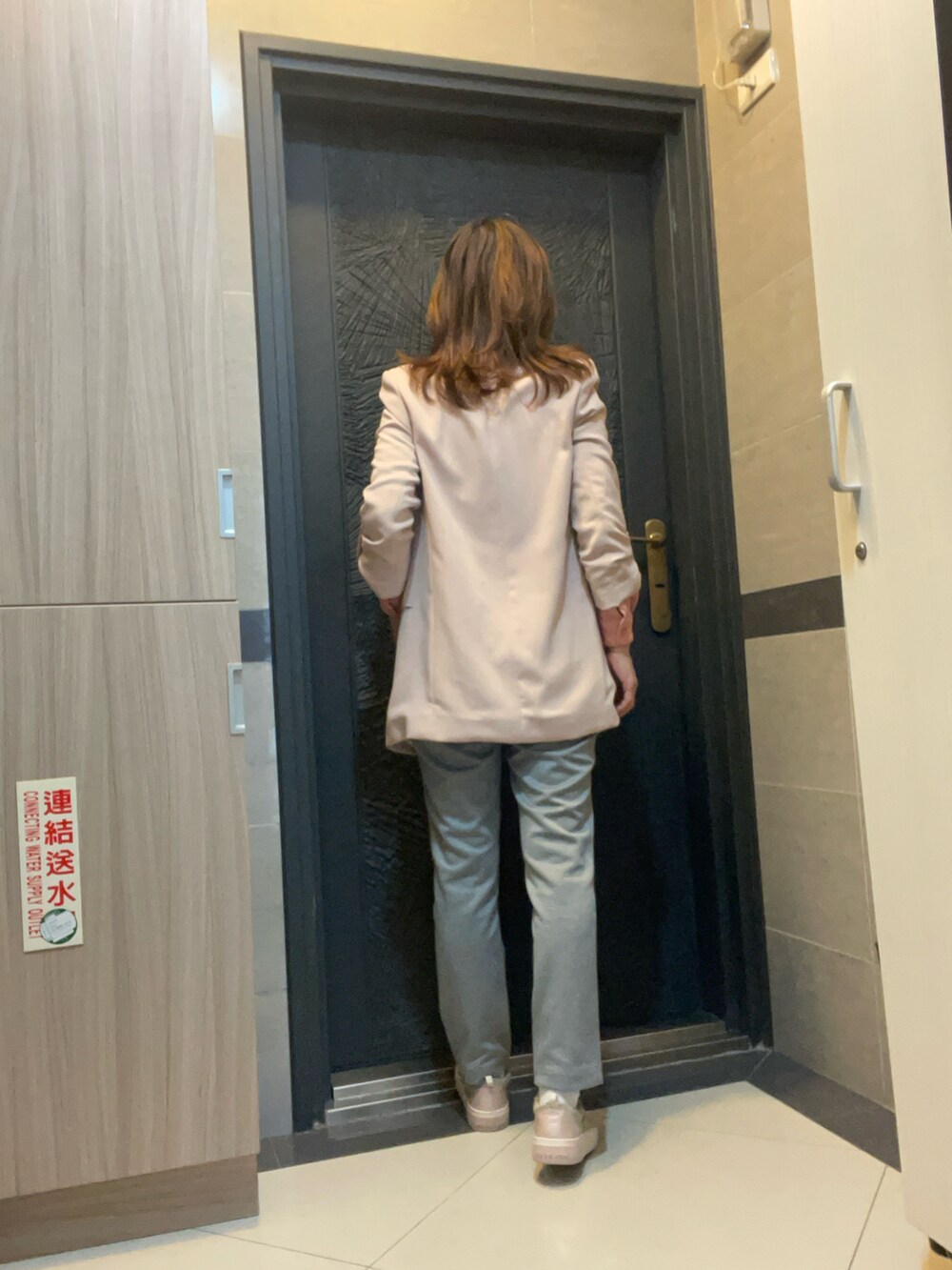 グレー系のチノパンツ、ピンク系のスニーカー、ピンク系のシャツ/ブラウスを着用したレディースの春コーディネートの3枚目の写真