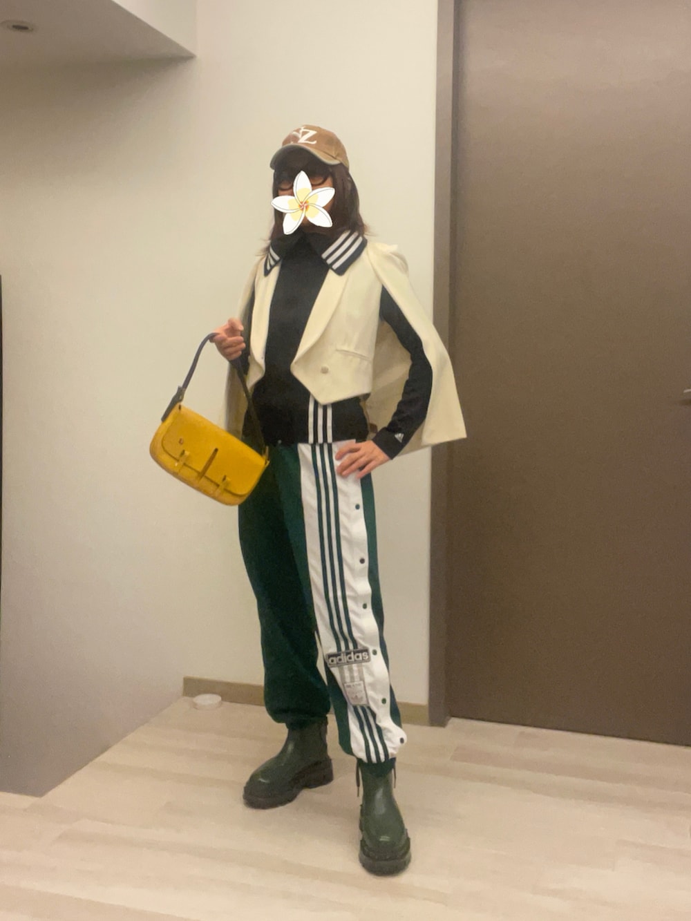 ベージュ系のステンカラーコート、グリーン系のチノパンツ、イエロー系のショルダーバッグを着用したレディースの春コーディネートの5枚目の写真