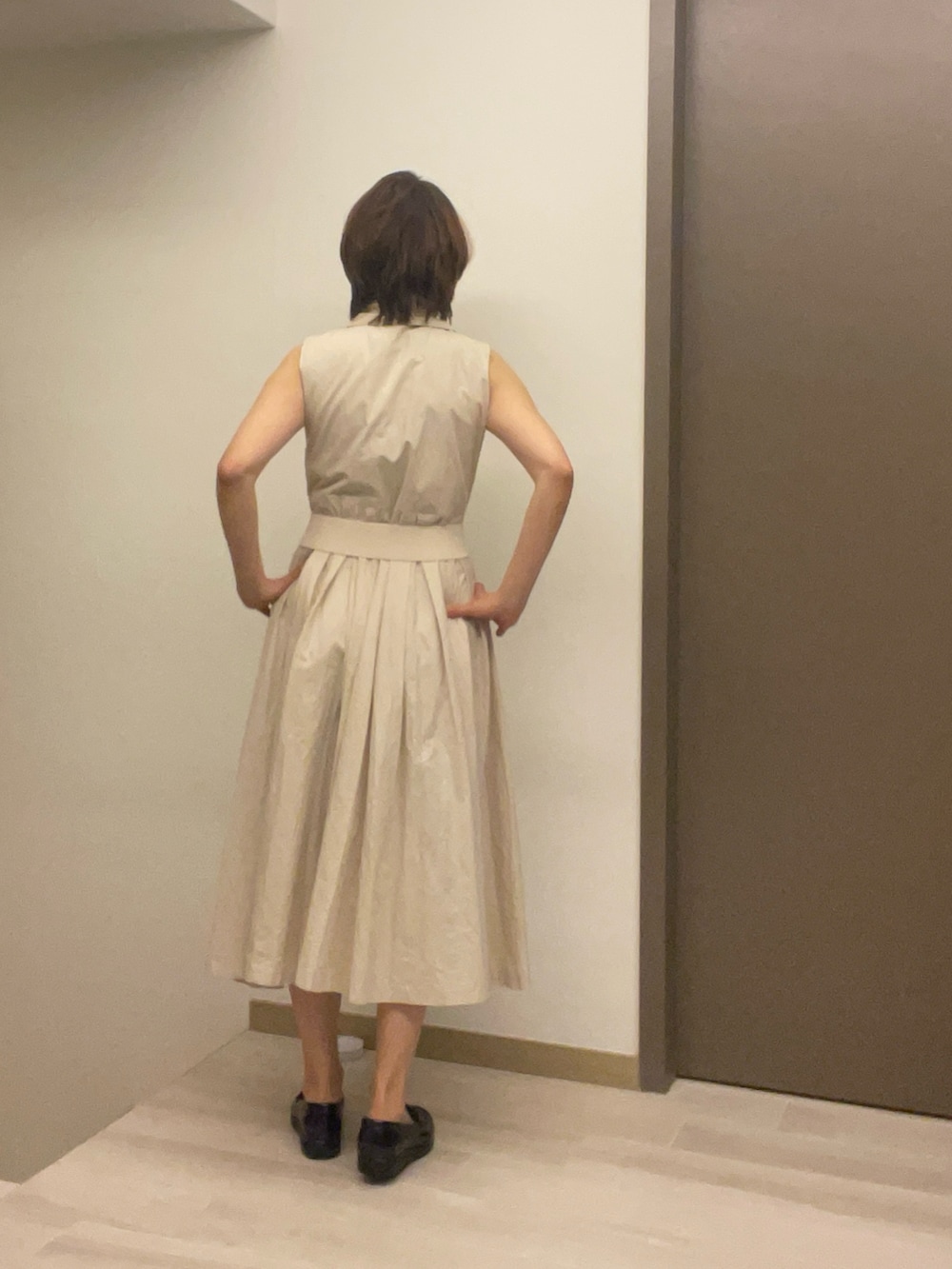 ベージュ系のシャツワンピース、ブラック系のスニーカー、イエロー系のショルダーバッグを着用したレディースの秋コーディネートの5枚目の写真