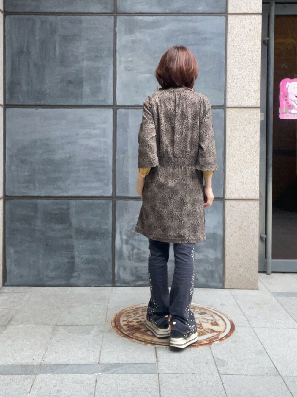 ブラック系のデニムパンツ、オレンジ系のシャツ/ブラウス、ブラック系のスニーカーを着用したレディースの夏コーディネートの4枚目の写真